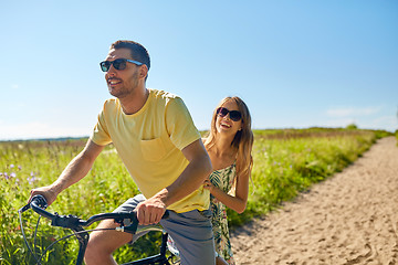 Image showing happy couple riding bicycle together in summer