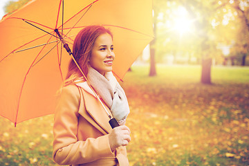 Image showing happy woman with umbrella walking in autumn park