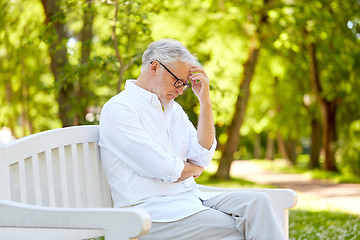 Image showing thoughtful senior man sitting at summer park