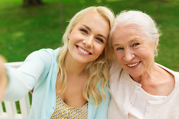 Image showing daughter and senior mother taking selfie at park