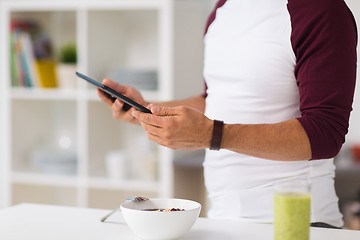 Image showing man with tablet pc having breakfast at home