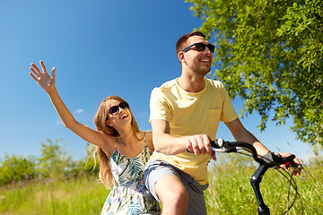 Image showing happy couple riding bicycle together in summer