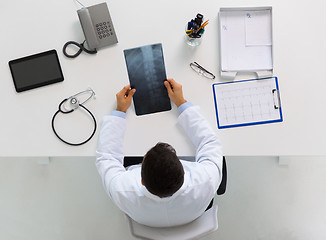 Image showing doctor with spine x-ray sitting at table