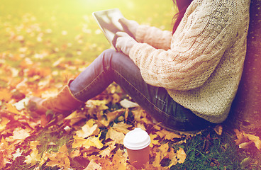 Image showing woman with tablet pc and coffee in autumn park