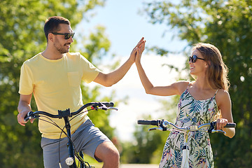 Image showing happy couple with bicycles making high five