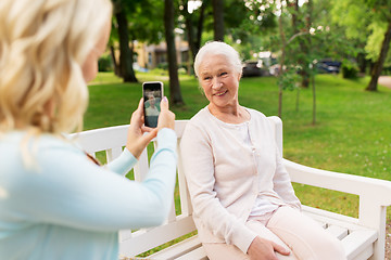 Image showing daughter photographing senior mother by smartphone