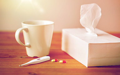 Image showing cup of tea, paper wipes and thermometer with pills