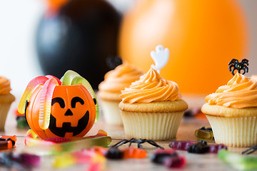 Image showing halloween party decorated cupcakes on wooden table