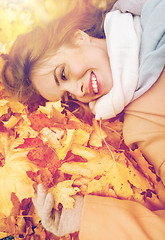 Image showing beautiful happy woman lying on autumn leaves