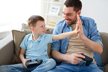 Image showing father and son with gamepads doing high five