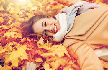 Image showing beautiful happy woman lying on autumn leaves