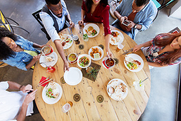 Image showing happy friends eating at restaurant