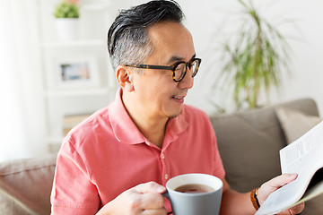 Image showing man drinking coffee and reading newspaper at home