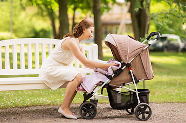 Image showing happy mother with child in stroller at summer park