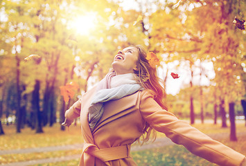 Image showing happy woman having fun with leaves in autumn park