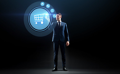 Image showing businessman with shopping cart on virtual screen