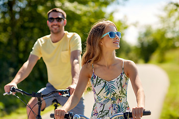 Image showing happy young couple riding bicycles in summer