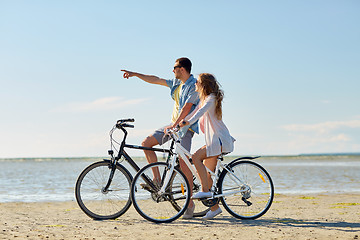 Image showing happy young couple riding bicycles at seaside