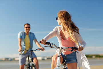 Image showing happy young couple riding bicycles at seaside