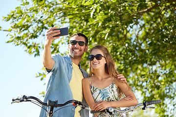 Image showing couple with bicycles taking selfie by smartphone