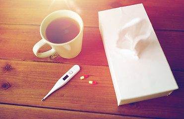 Image showing cup of tea, paper wipes and thermometer with pills