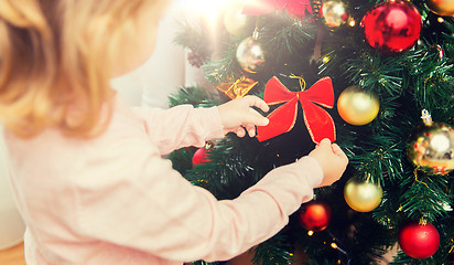 Image showing close up of little girl decorating christmas tree