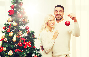 Image showing happy couple decorating christmas tree at home