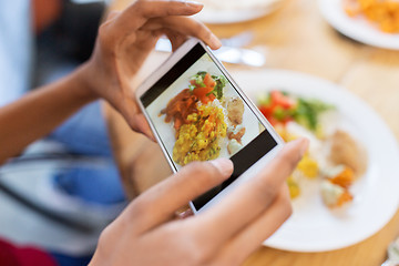 Image showing hands with smartphone picturing food at restaurant