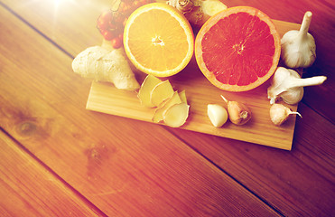 Image showing citrus fruits, ginger and garlic on wood