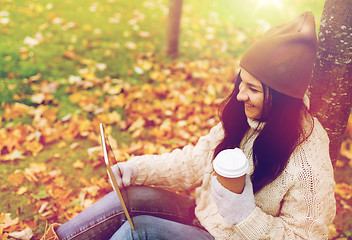 Image showing woman with tablet pc and coffee in autumn park