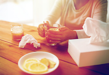 Image showing ill woman drinking tea with lemon and honey