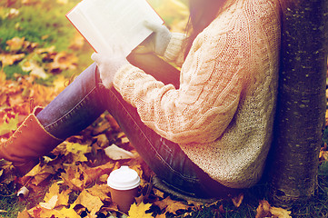 Image showing woman with book drinking coffee in autumn park