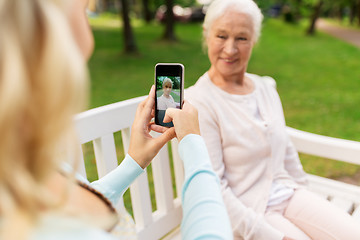 Image showing daughter photographing senior mother by smartphone