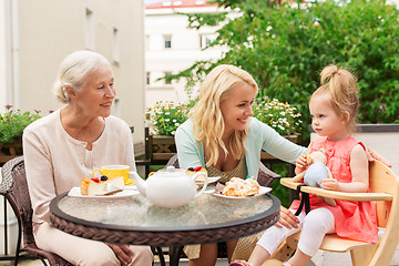 Image showing woman with daughter and senior mother at cafe