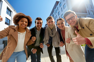 Image showing group of people showing thumbs up in city