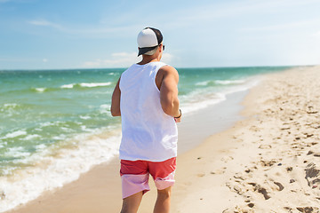 Image showing happy man running along summer beach