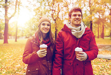 Image showing happy couple with coffee walking in autumn park