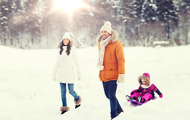 Image showing happy family with sled walking in winter forest