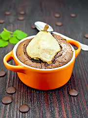 Image showing Cake chocolate with pear in red bowl on dark board