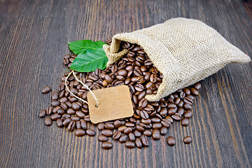 Image showing Coffee black grain with tag and leaf in bag on board