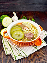 Image showing Soup with zucchini and noodles in red bowl on towel