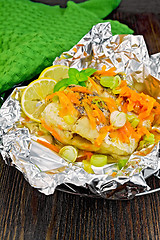 Image showing Pike with leeks and carrots in foil on board