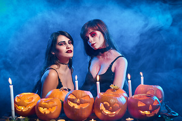 Image showing Two beautiful sexy witches with Halloween pumpkins