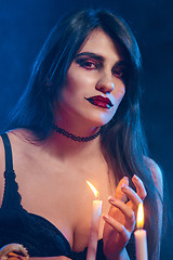 Image showing Beautiful witch with Halloween pumpkins