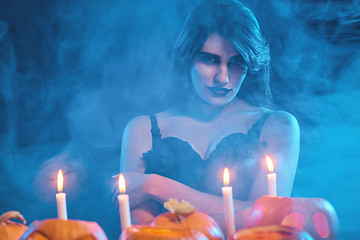 Image showing Beautiful witch with Halloween pumpkins