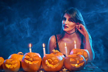 Image showing Beautiful witch with Halloween pumpkins