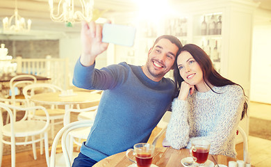 Image showing couple taking smartphone selfie at cafe restaurant