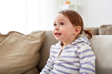 Image showing happy smiling baby girl sitting on sofa at home