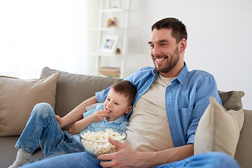 Image showing father and son with popcorn watching tv at home