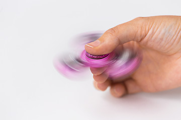 Image showing close up of hand playing with fidget spinner